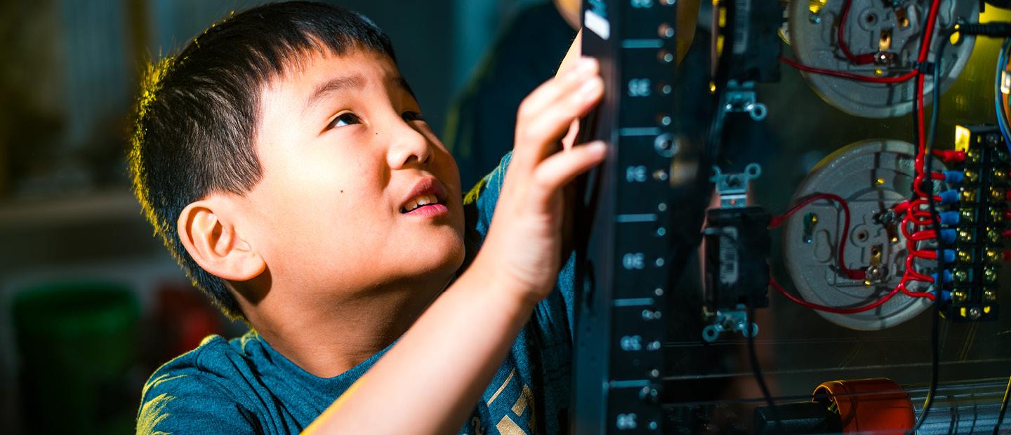 Young boy working on a piece of electrical equipment